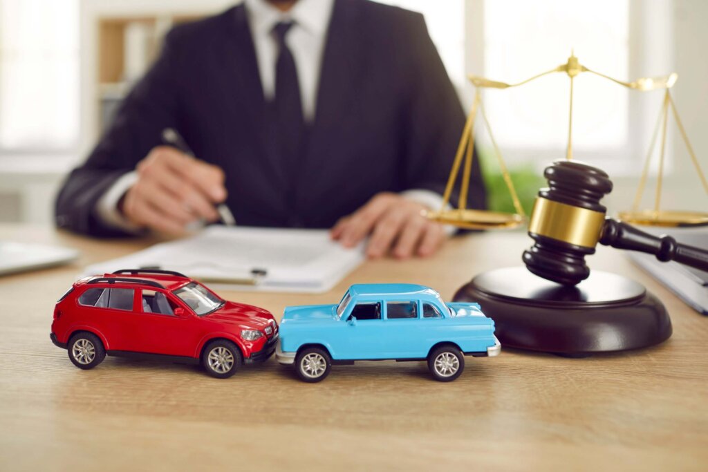 Two toy model cars in the background of a judge hearing a lawsuit in a car accident